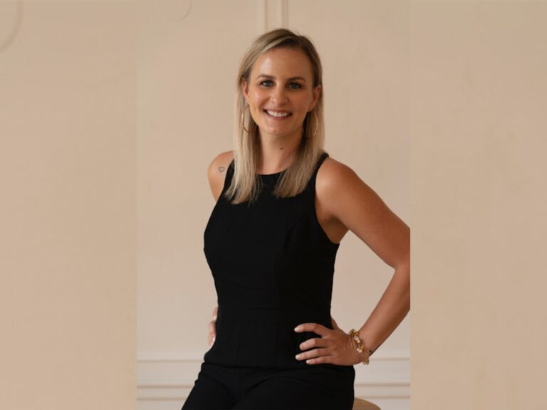 Jennifer Presser wearing comfy balck clothes smiling and standing with her hand on her hip inside.